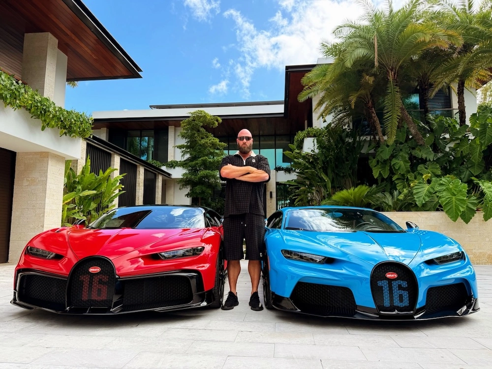 Richard Skelhorn stood between his red and blue Bugattis